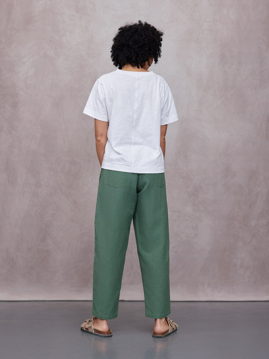 Myrtle Barrel Leg Trouser in green, rear view, worn with white tee and sandals against a neutral studio background.