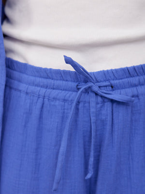 Joy Cotton Crinkle Trouser in cobalt blue, close-up of elasticated drawstring waistband, paired with a white ribbed top.