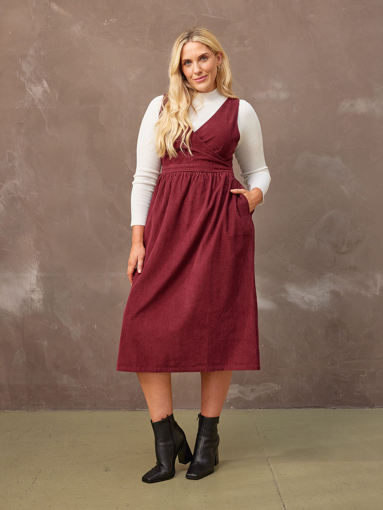 A model poses with her hand in the pocket of the Ally corduroy dress.