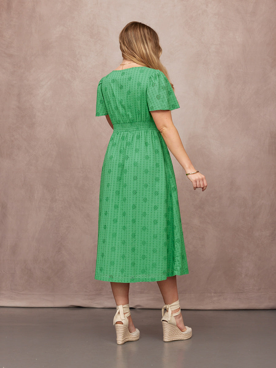 Allegra Broderie Dress in green, back view, short sleeves, shirred waist, midi length, worn with cream espadrille wedges