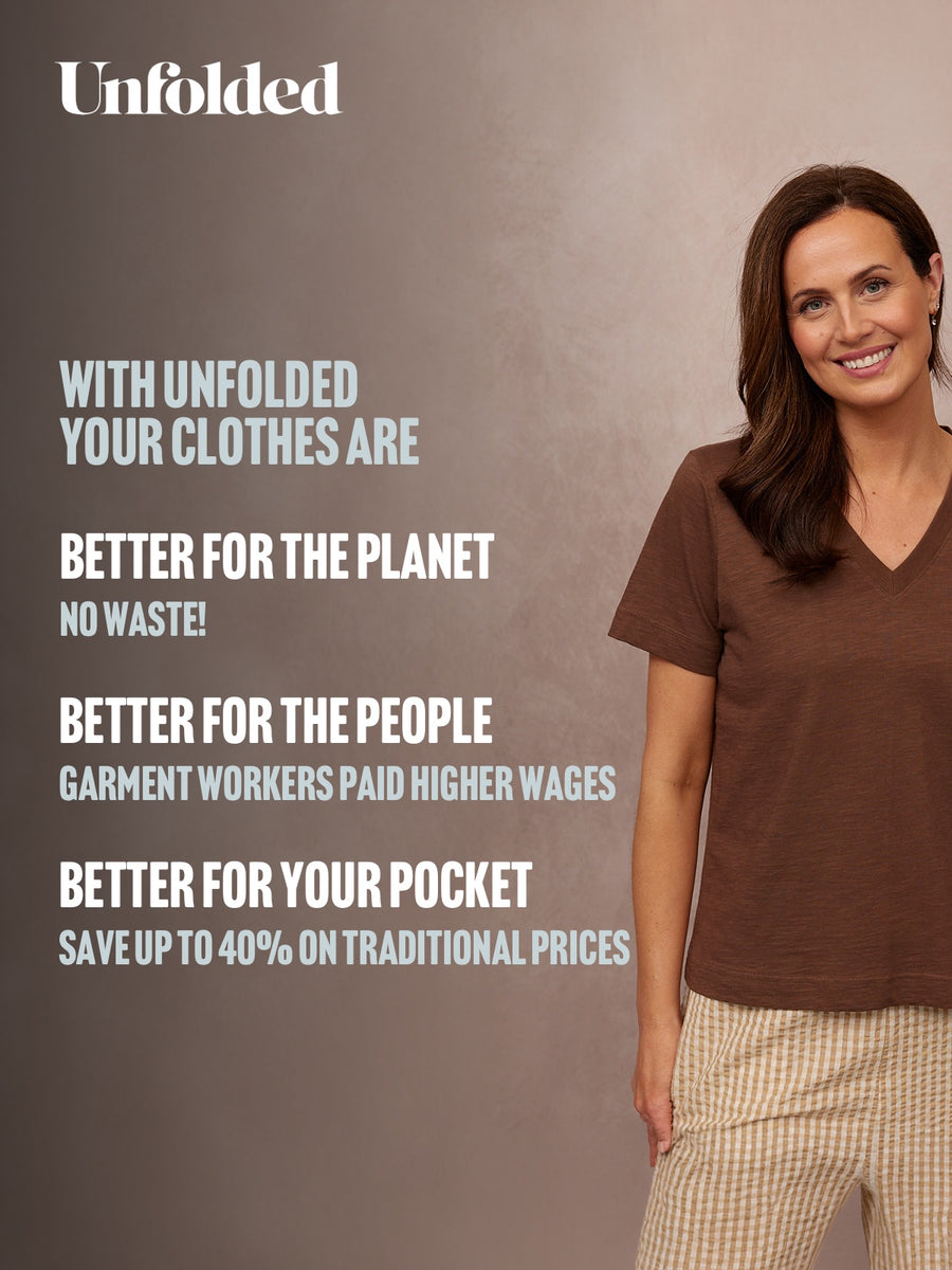 Unfolded Cathy V-neck Tee in brown, worn by smiling woman with striped trousers against neutral studio background