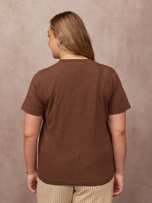 Cathy V-neck Tee in brown, back view on plus-size model, short sleeves, paired with checkered trousers