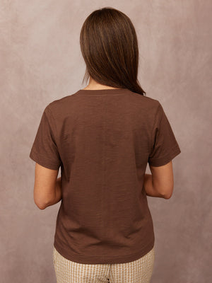 Cathy V-neck Tee in brown, back view on model, short sleeves, centre back seam, paired with check shorts