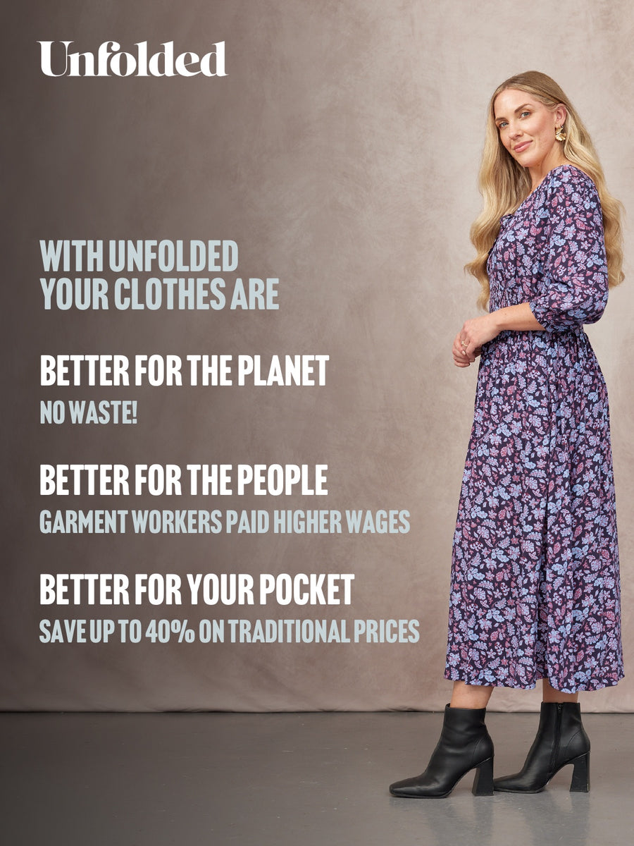 Model in a navy floral midi dress with three-quarter sleeves, styled with black heeled ankle boots.