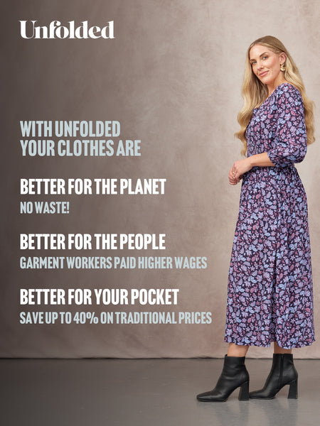 Model in a navy floral midi dress with three-quarter sleeves, styled with black heeled ankle boots.
