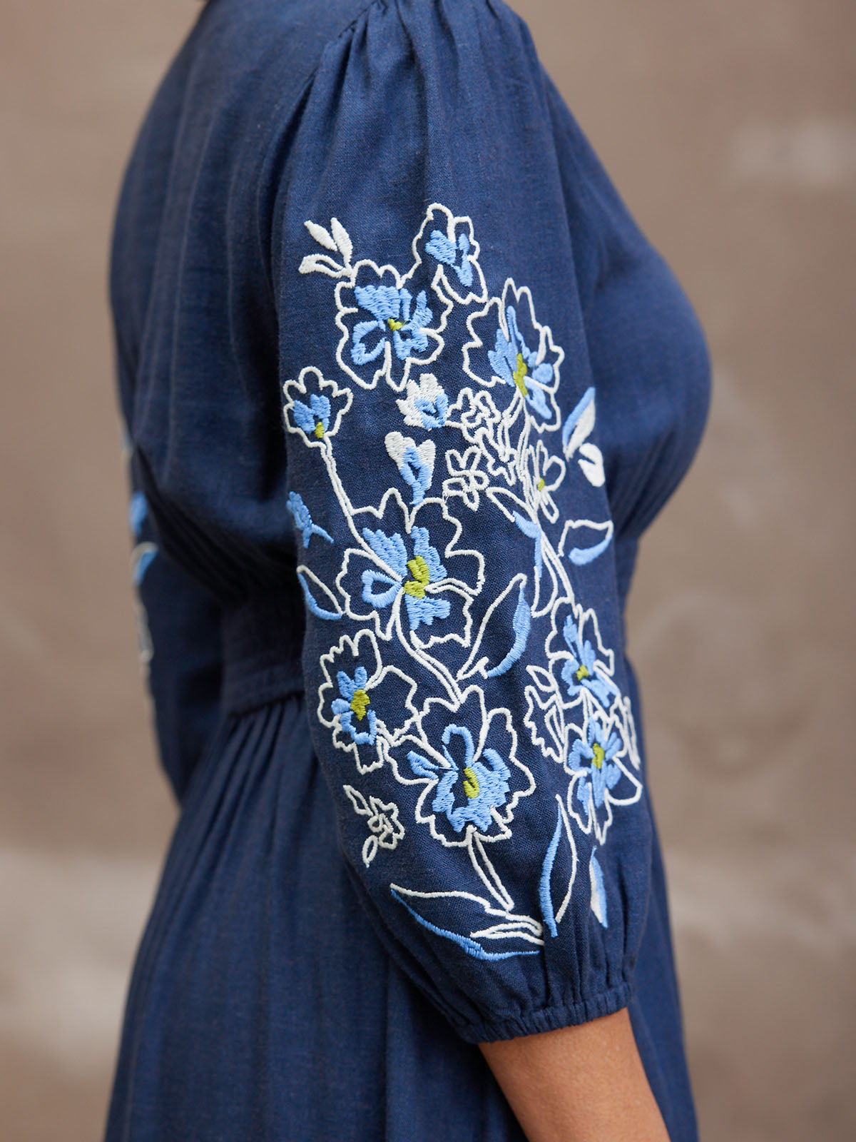 Blue dress with floral embroidery on the sleeve.