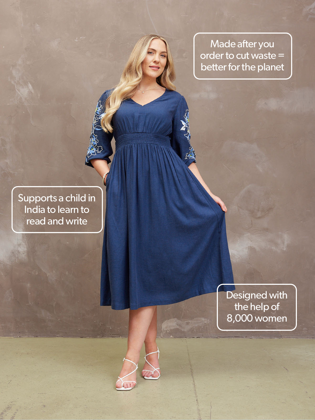 Woman in blue dress with embroidered sleeves, standing with described eco-friendly and charitable features.