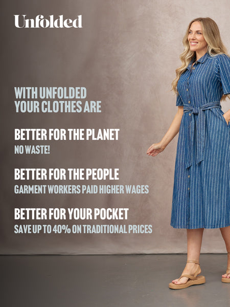 Model wearing a blue pinstripe short-sleeve shirt dress with tie belt and gold buttons, styled with tan flatform sandals.