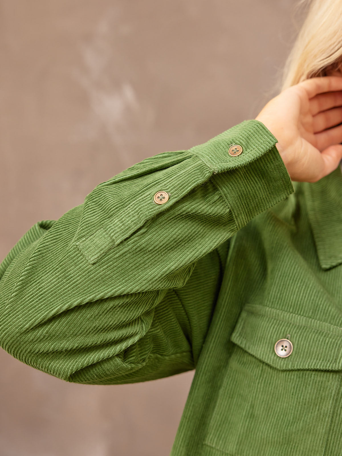 Close up sleeve placket detail of the sustainable Yasmynn shacket in olive, with two buttons.