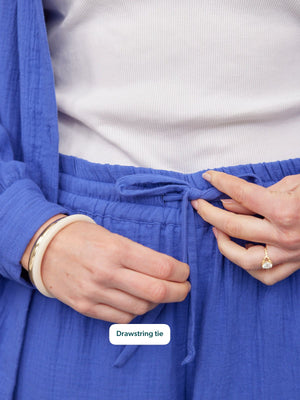 Joy Cotton Crinkle Trouser in cobalt blue, close-up of elasticated drawstring waistband, worn with white ribbed top.