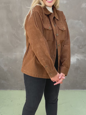 Video of a model showing off the sustainable Yasmynn corduroy shacket in brown, paired with a white top and black trousers