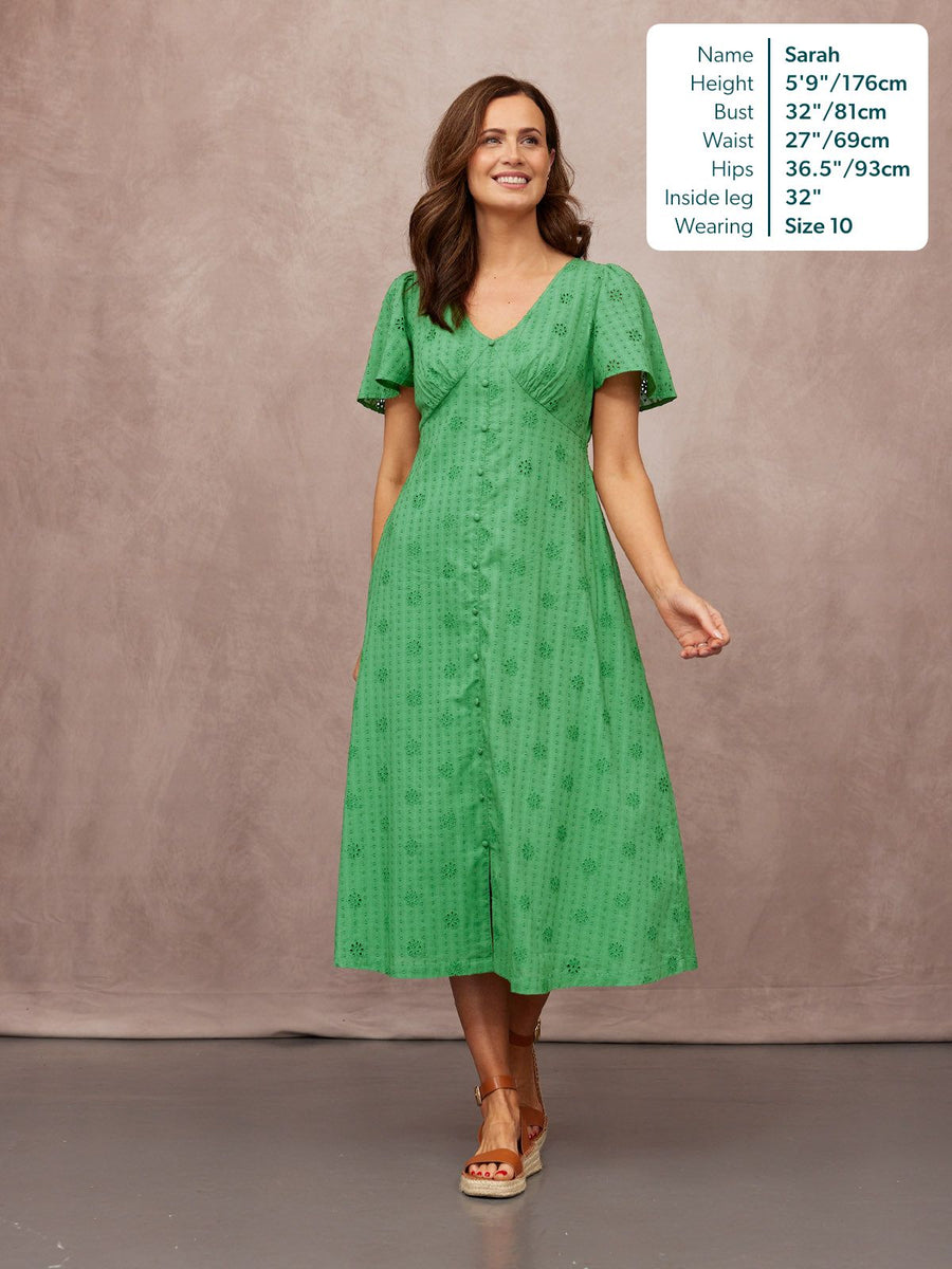 Allegra Broderie Dress in green, V-neck flutter sleeves, button-front midi length with eyelet detail, worn with tan wedge sandals