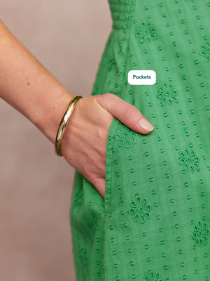 Allegra Broderie Dress in green - close-up of floral eyelet fabric and side pocket with model's hand resting inside