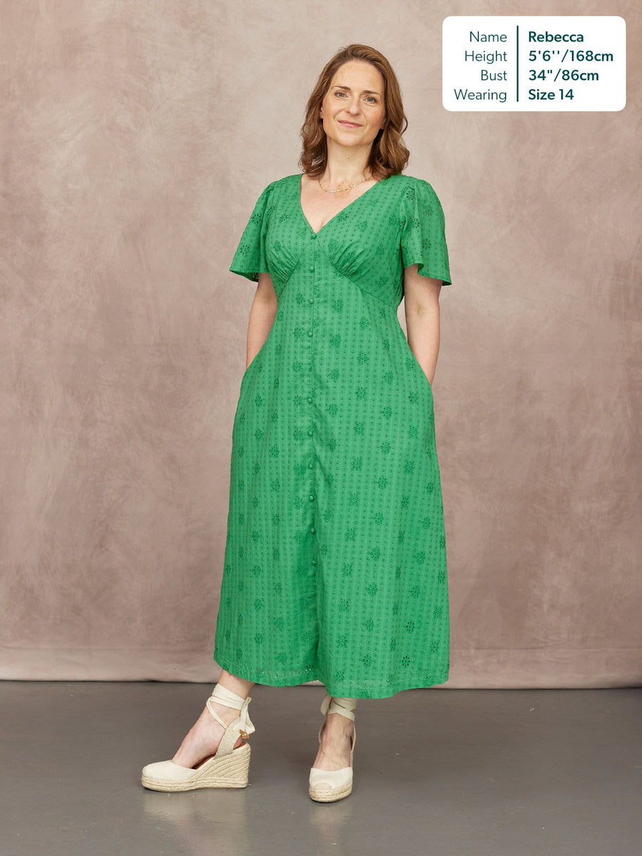 Allegra Broderie Dress in green, V-neck button-through midi with flutter sleeves and floral broderie, worn with cream wedge sandals