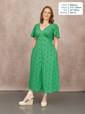 Allegra Broderie Dress in green, V-neck button-through midi with flutter sleeves and floral broderie, worn with cream wedge sandals