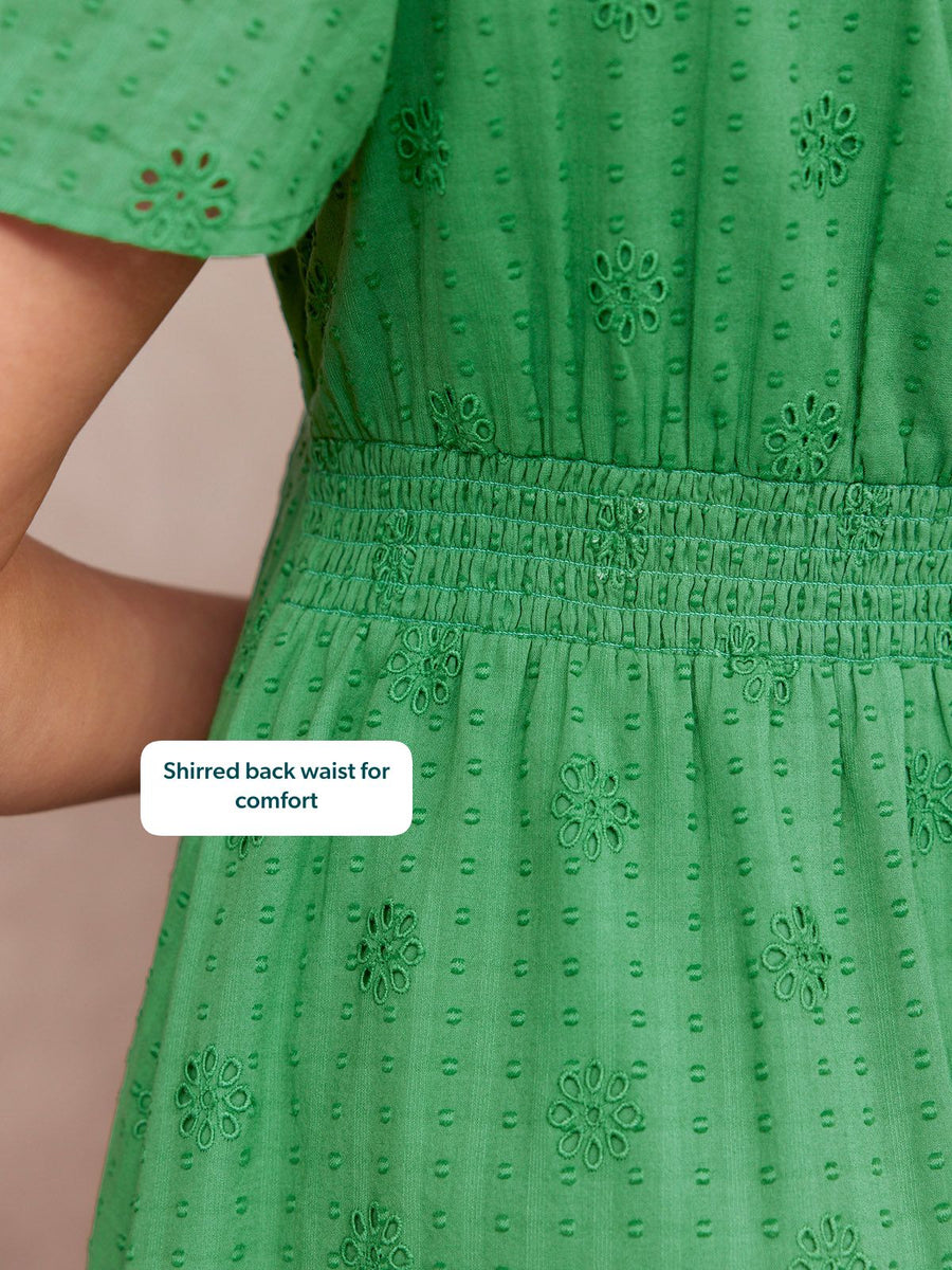 Allegra Broderie Dress in green – close-up of shirred back waist, broderie anglaise floral detail and short puff sleeve