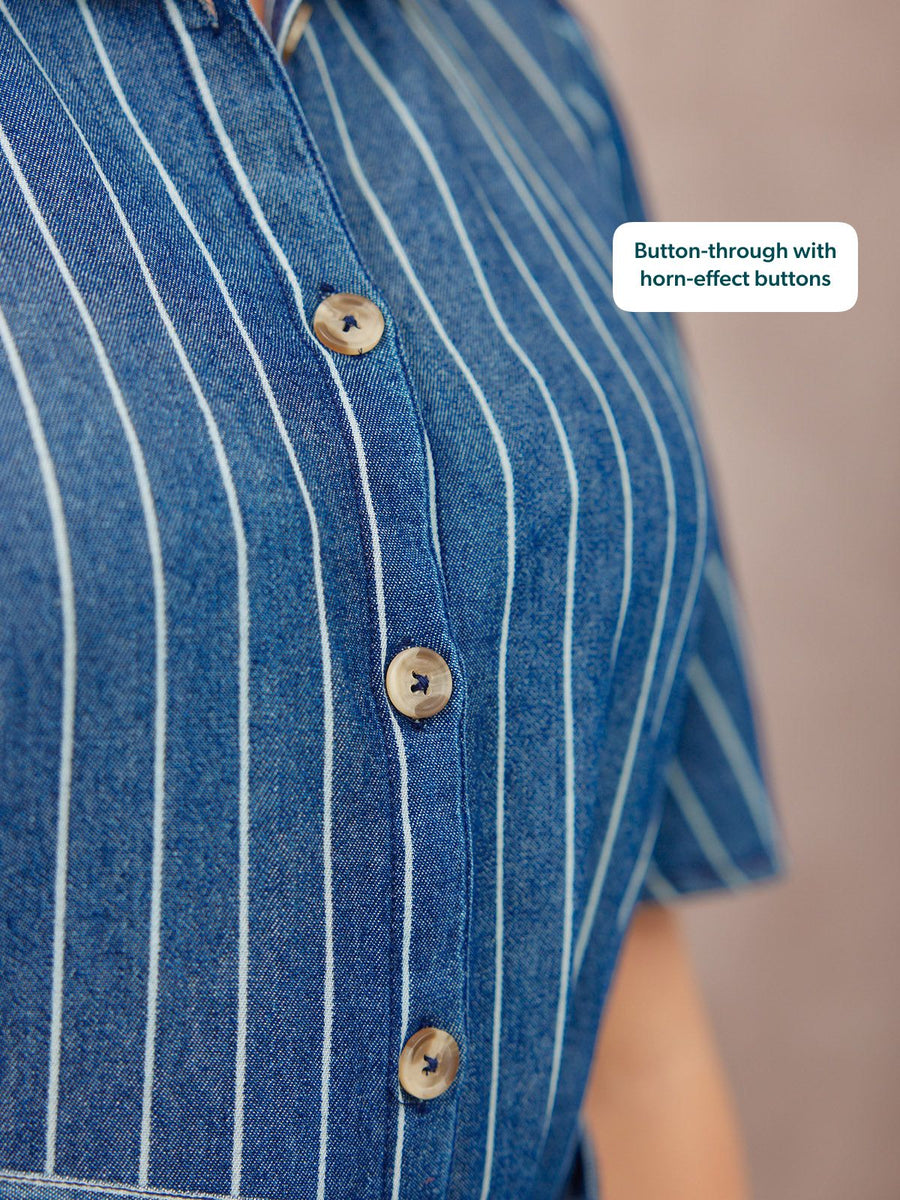 Close-up of a blue denim pinstripe shirt with horn-effect buttons on a model.