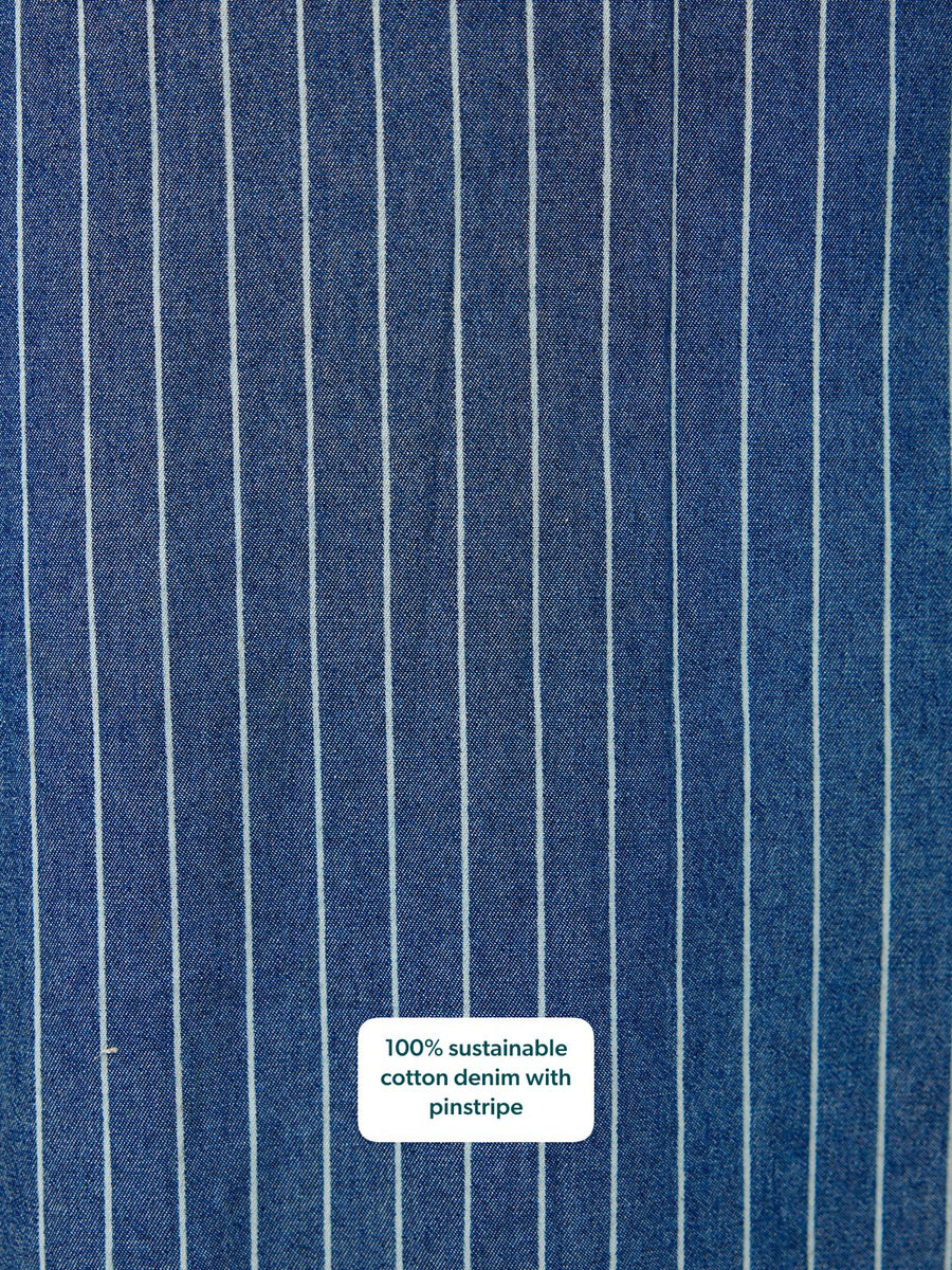 Close-up of blue denim fabric with white vertical pinstripes.