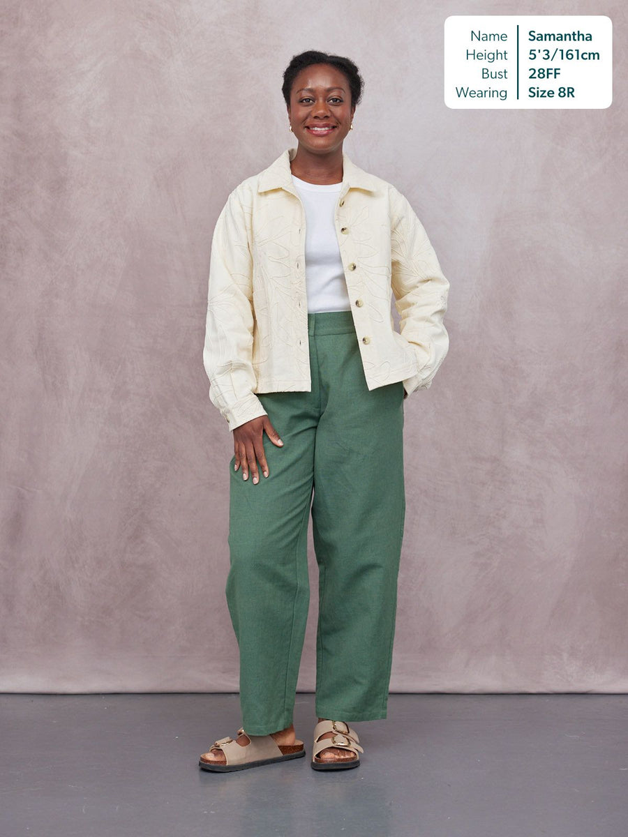 Myrtle Barrel Leg Trouser in green, worn by a model with a cream embroidered jacket and sandals, full-length front view