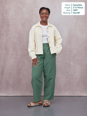 Myrtle Barrel Leg Trouser in green, worn by a model with a cream embroidered jacket and sandals, full-length front view