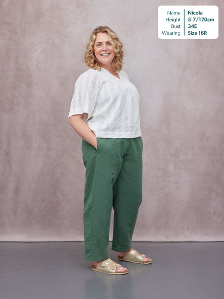 Myrtle Barrel Leg Trouser in green, worn by a model with a white V-neck top and gold sandals, relaxed straight-leg fit