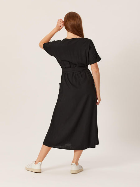 A model wears the Daisy wrap dress from Unfolded, pcitured from behind with her hair pulled to one side. 
