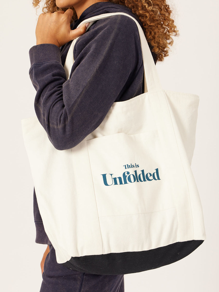 A model carries a Joey bag on their shoulder whilst wearing a coordinating set of Robyn joggers and a Willow hoodie, pictured against a white backdrop. 