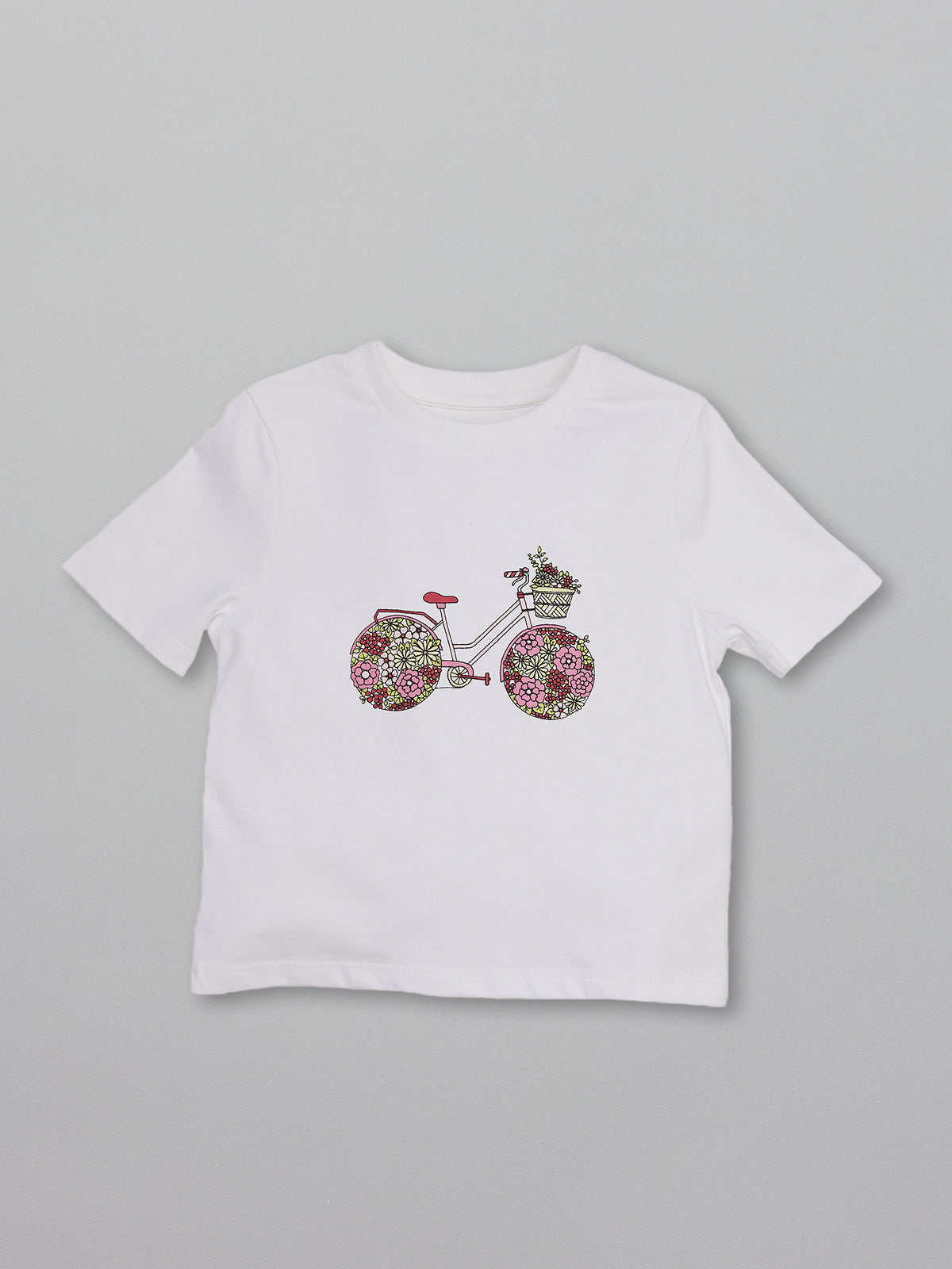 Eco-friendly kids t-shirt with a multicolour bicycle print on a white base, pictured from the front.  