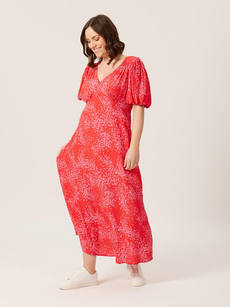 A model wearing the eco-friendly Lauren midi dress, pictured smiling and looking towards the ground.