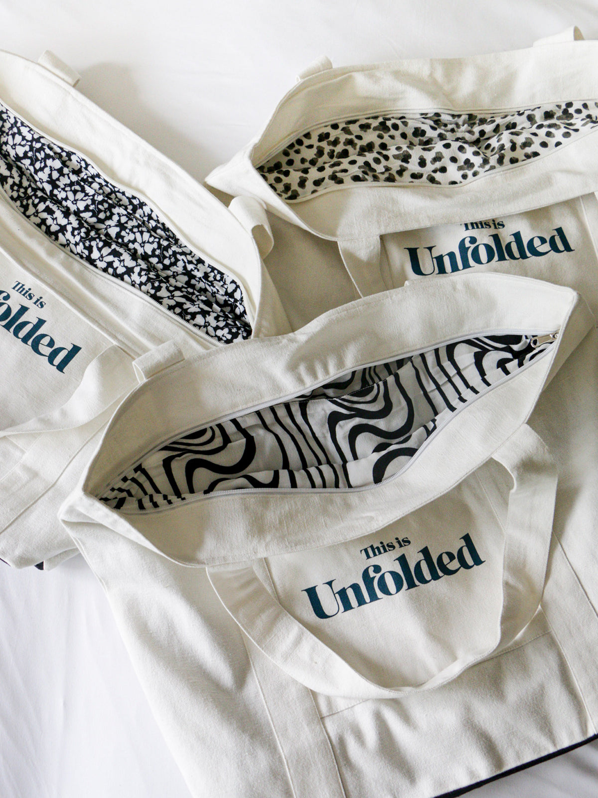 Three Joey bags are laid together with their individual linings displayed, pictured against a white backdrop. 