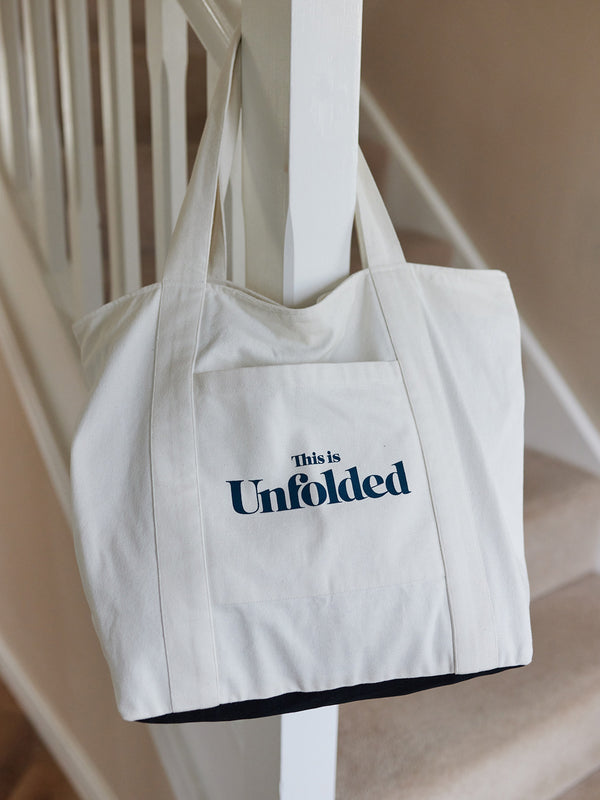 A Joey bag is pictured hanging on a bannister rail at the foot of a flight of stairs in a home. 