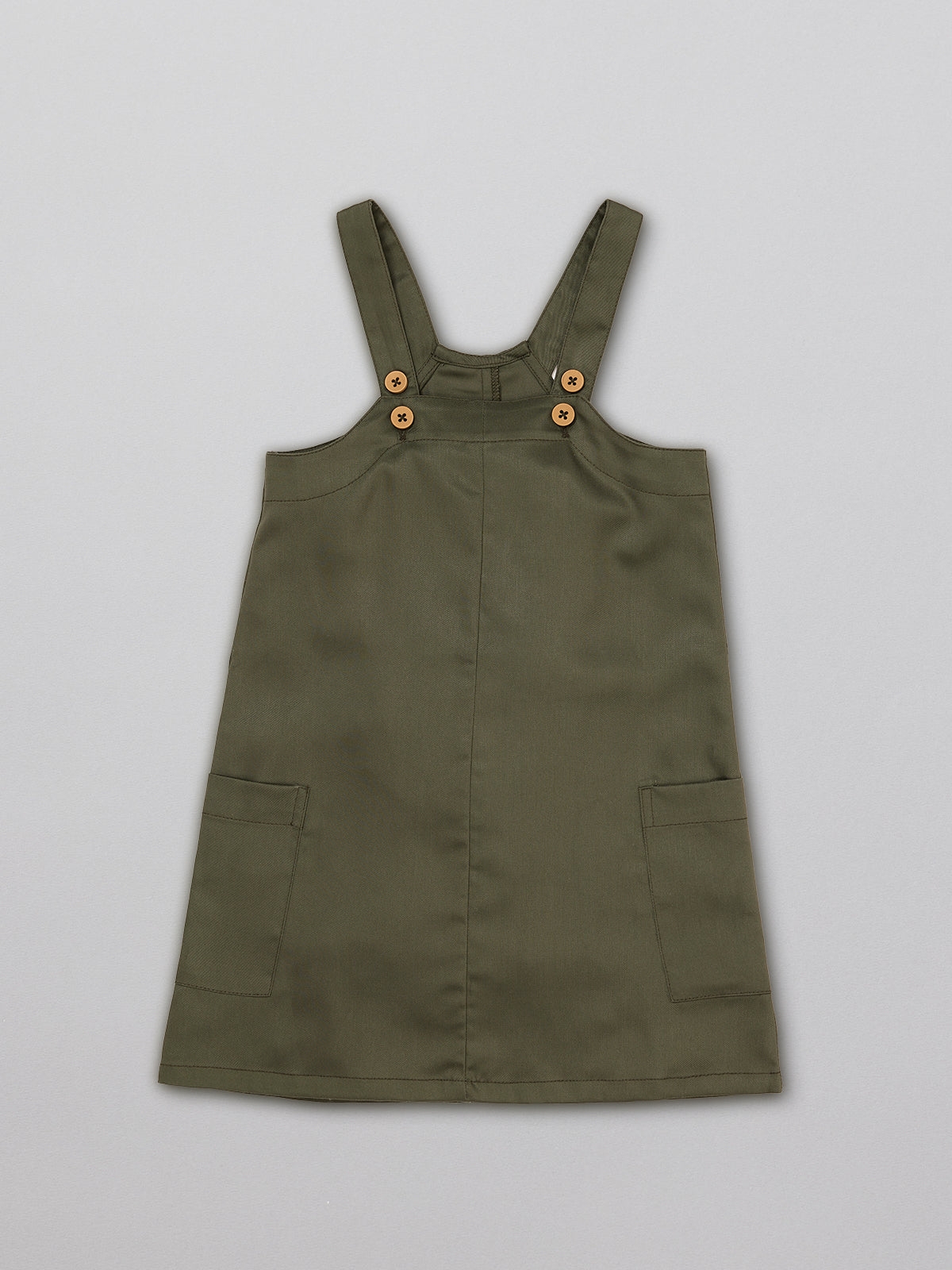 Sustainable kids pinafore dress with pockets, pictured from the front.