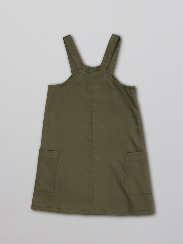 Sustainable kids pinafore dress with pockets, pictured from the back.