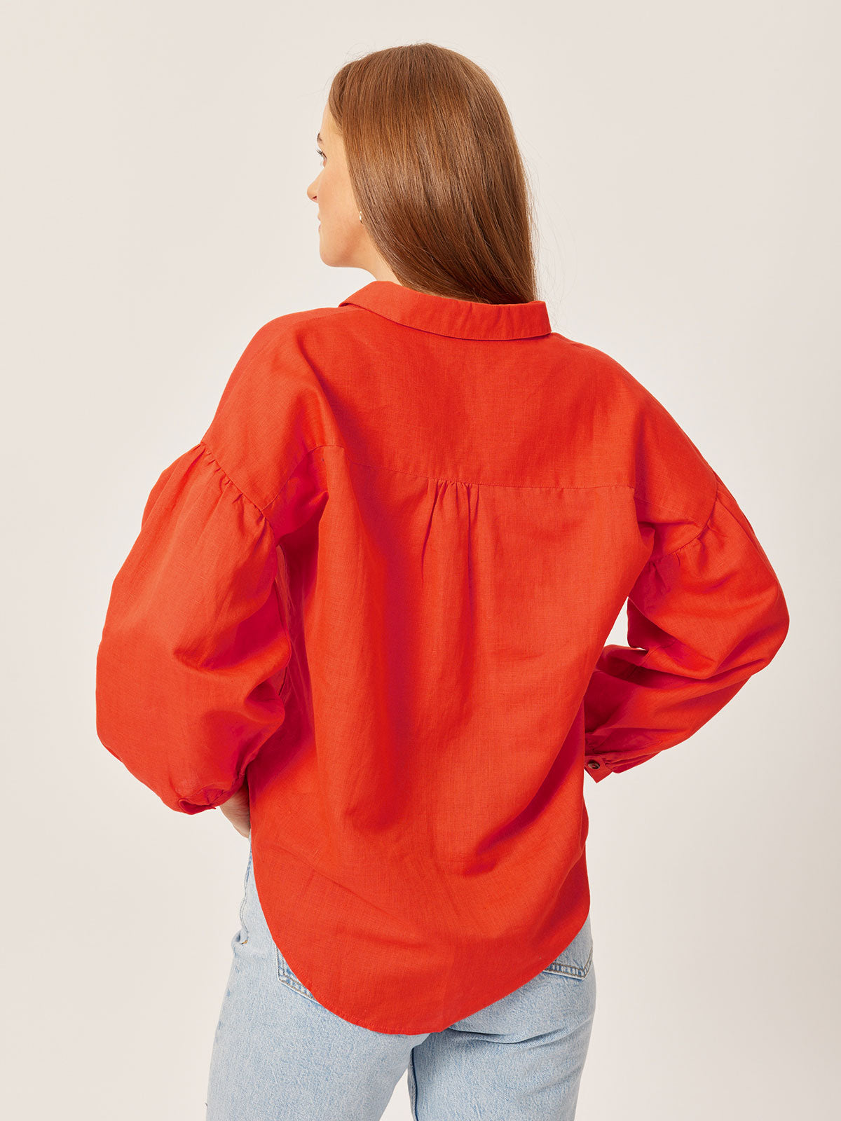A model is pictured from behind wearing the sustainable Martha shirt, with their hair pulled to one side. 