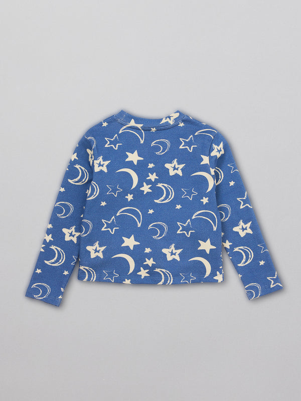 A sustainable kids pyjama top in blue with a white moon and star print, pictured from the back.