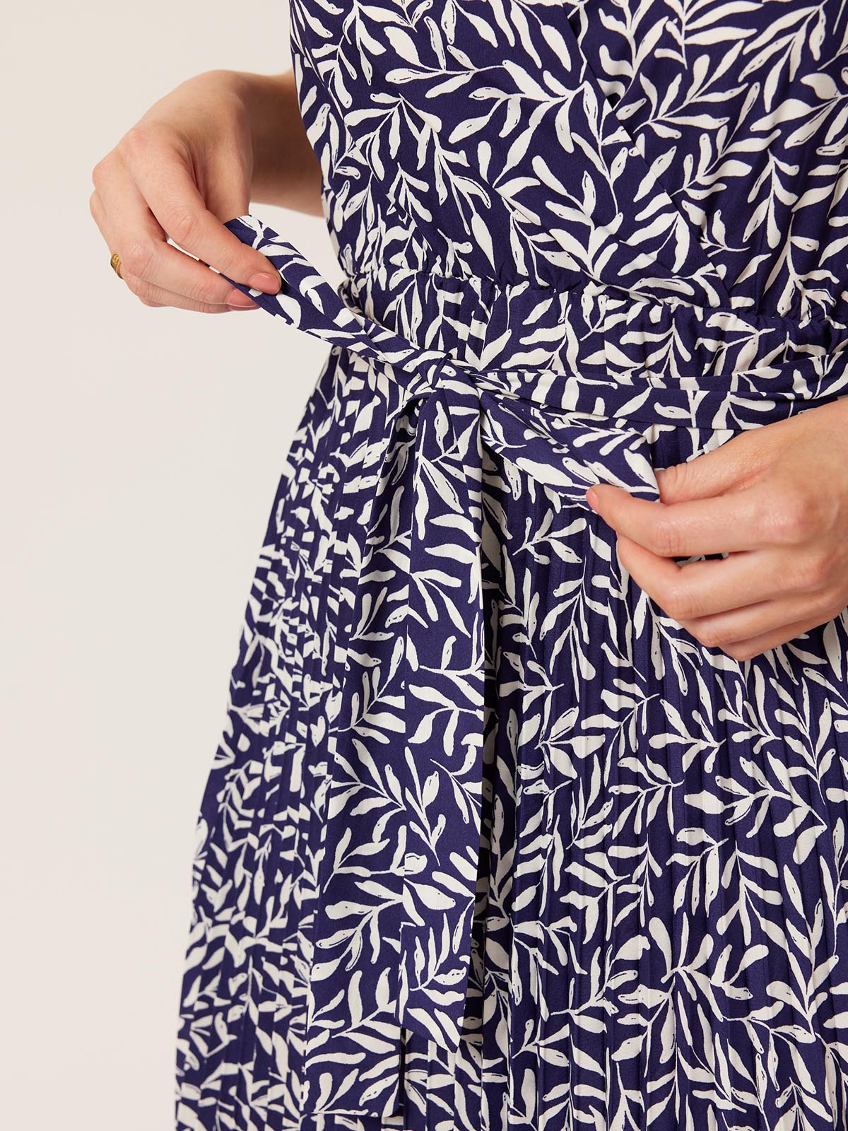 A close up of a model wearing the Nena wrap dress, with a focus on the tie at the waist. 
